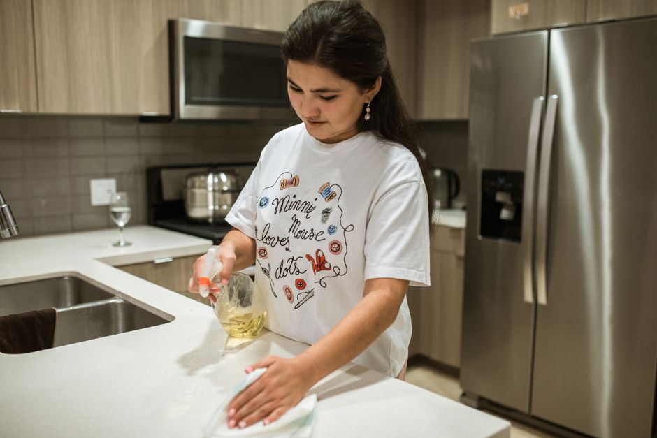Professional cleaner wiping down kitchen surfaces